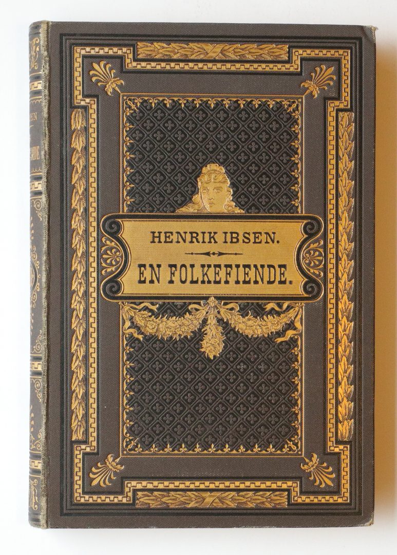 Ornate dark brown hardcover with gold-embossed border and a central gold label reading 'HENRIK IBSEN. EN FOLKEFIENDE'.